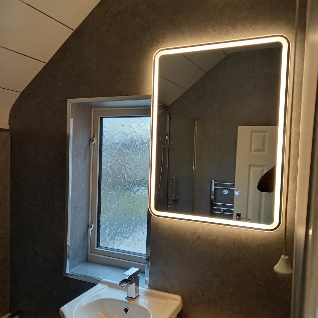 Bathroom plumbing installation with illuminated mirror and modern basin