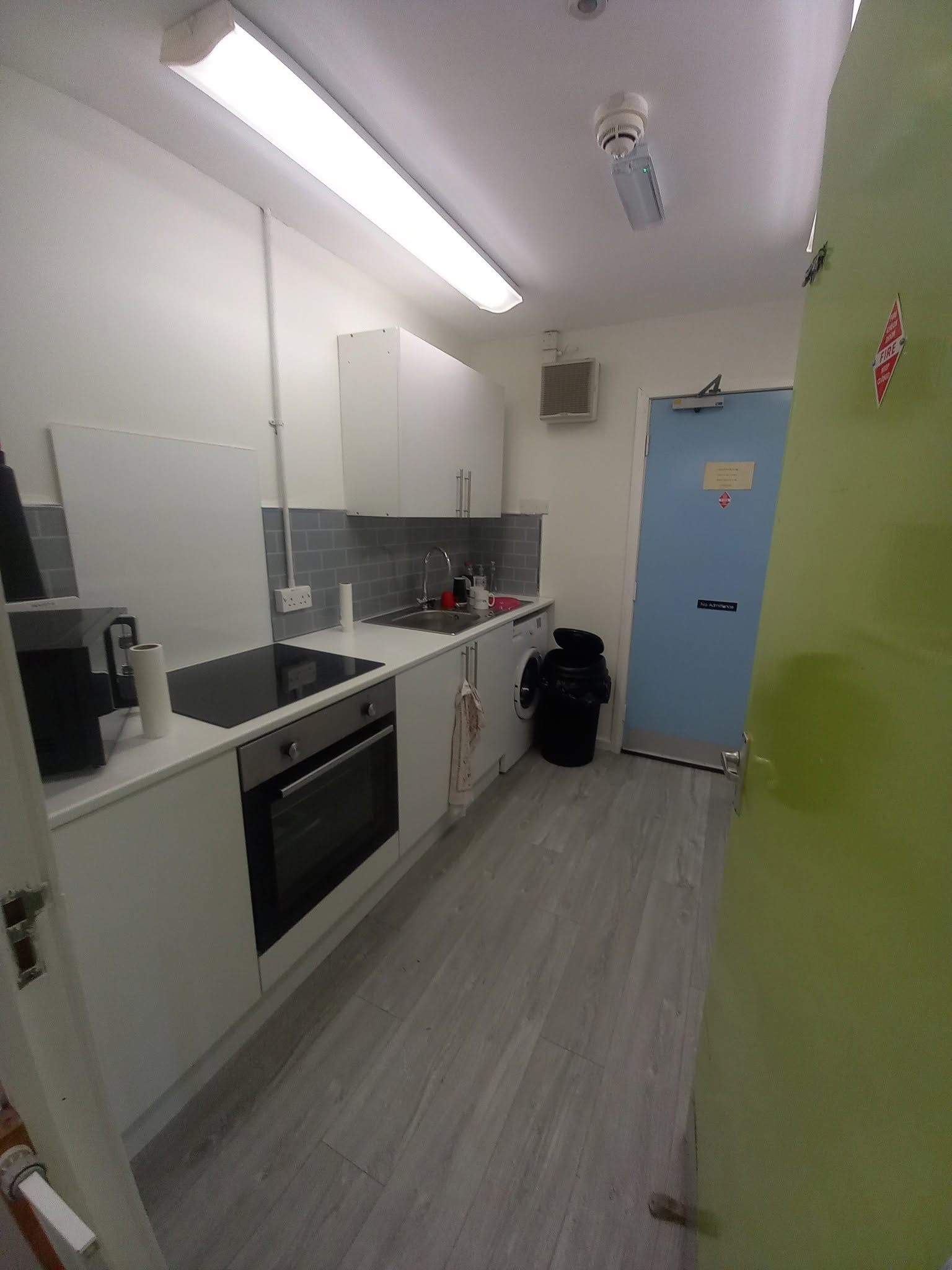 Kitchenette refurbishment with subway tile splashback and integrated appliances