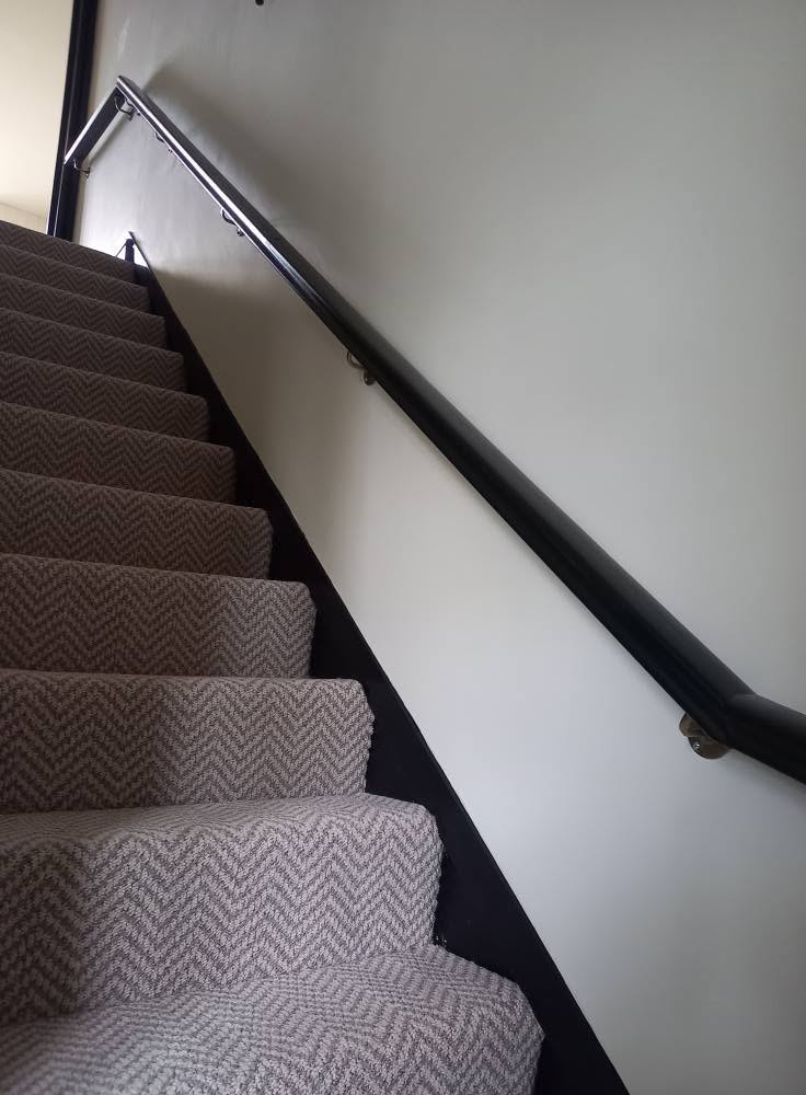 Staircase decorating with fitted carpet, painted trim and handrail